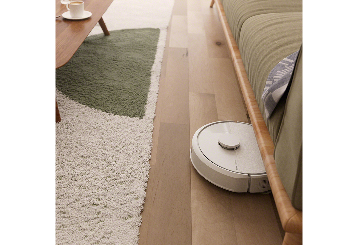 Παρουσιάζεται η σκούπα να καθαρίζει το πάτωμα ενός σαλονιού με χαλιά.